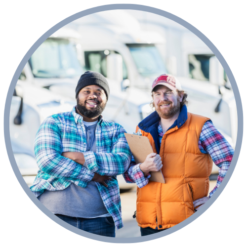 Two truck drivers smiling outside of a fleet