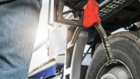 Semi-truck fueling at a truck stop, representing cost-plus fuel pricing and fuel savings for owner-operators and fleets.
