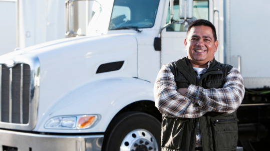 Truck driver smiling in front of truck